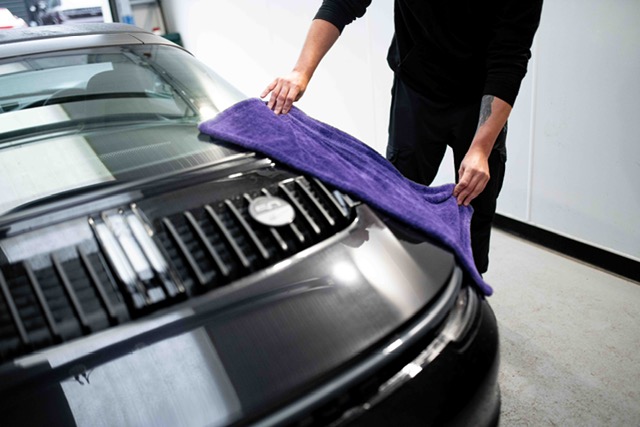 iValet detailer drying a car bonnet with microfibre